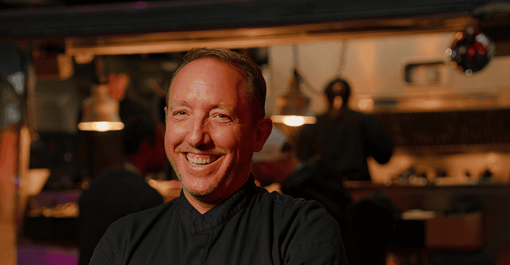 Gastronom und Koch Markus Grein steht beim Messe-Catering vor einem Foodtruck, bei dem Streetfood serviert wird