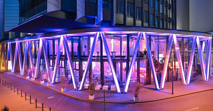 Lila beleuchtete Außenfassade der Frankfurter Eventlocation Westhafen Pier 1 am Abend.