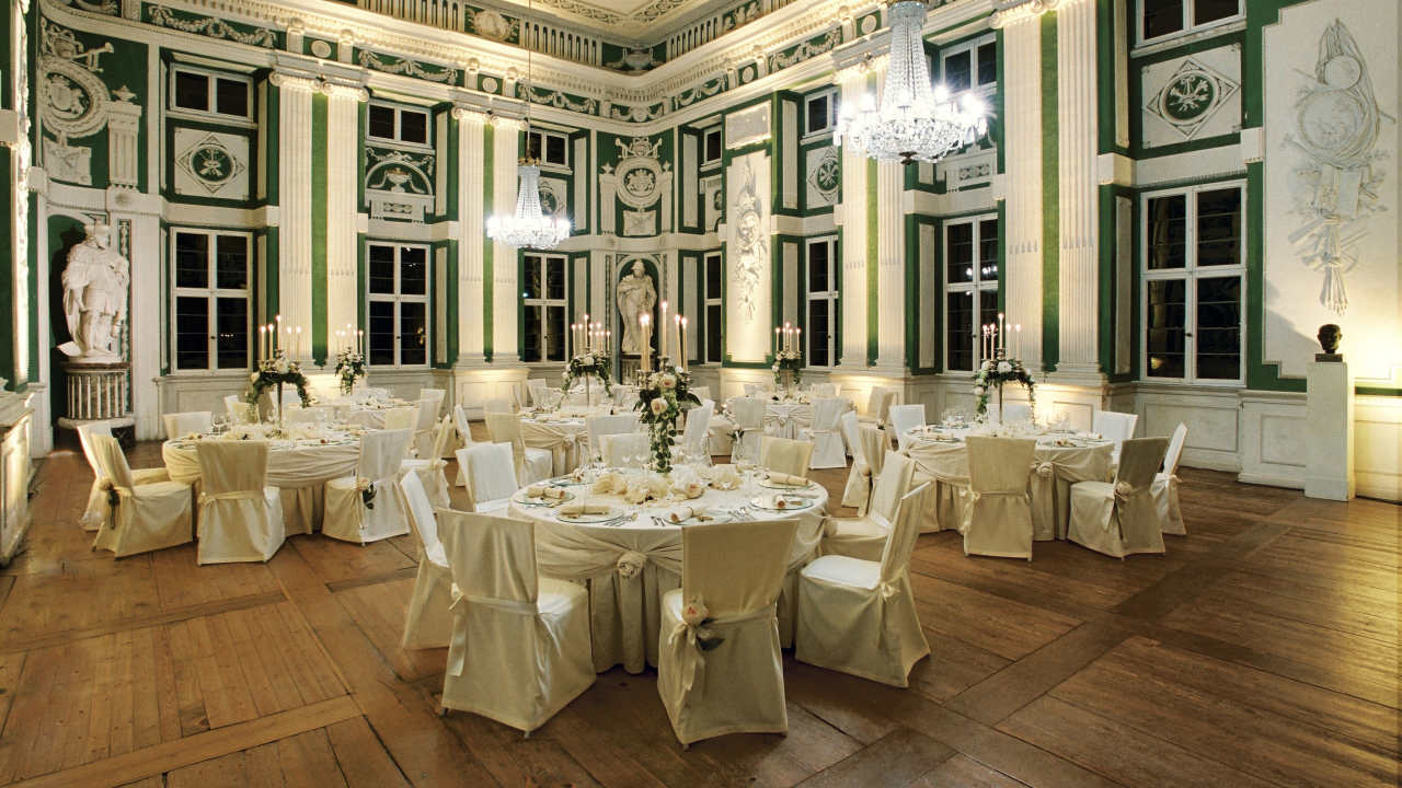 Festlich, traditionell eingerichteter Saal der Eventlocation Fürstliche Abtei in Amorbach mit Tischen und Stühlen mit Hussen.