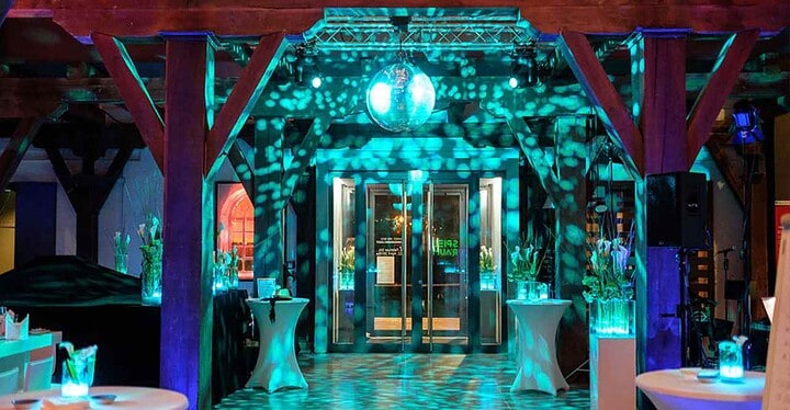 Bunt beleuchteter Veranstaltungsraum mit Discokugel an der Decke im Kulturspeicher in Würzburg.