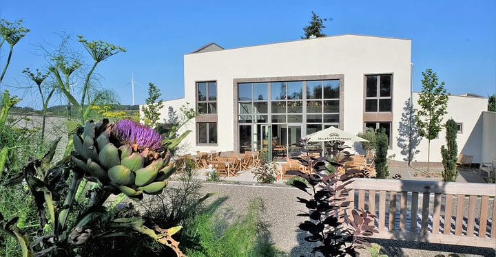 Außenbereich mit Blick auf die Eventlocation und Hochzeitslocation Villa Oriental in Ahorn im Hintergrund bei Sonnenschein.