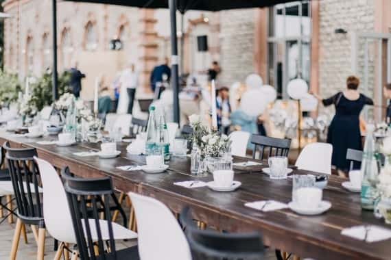 Hochzeitscatering mit festlich gedeckter Tafel im Außenbereich der Würzburger Hochzeitslocation Bürgerbräu.