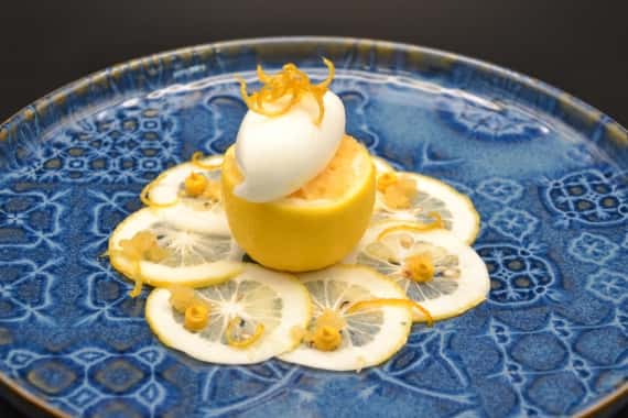 Zitronensorbet in ausgehöhlter Zitrone auf dünnen Zitronenscheiben als Dessert bei einem Hochzeits-Catering in Nürnberg.
