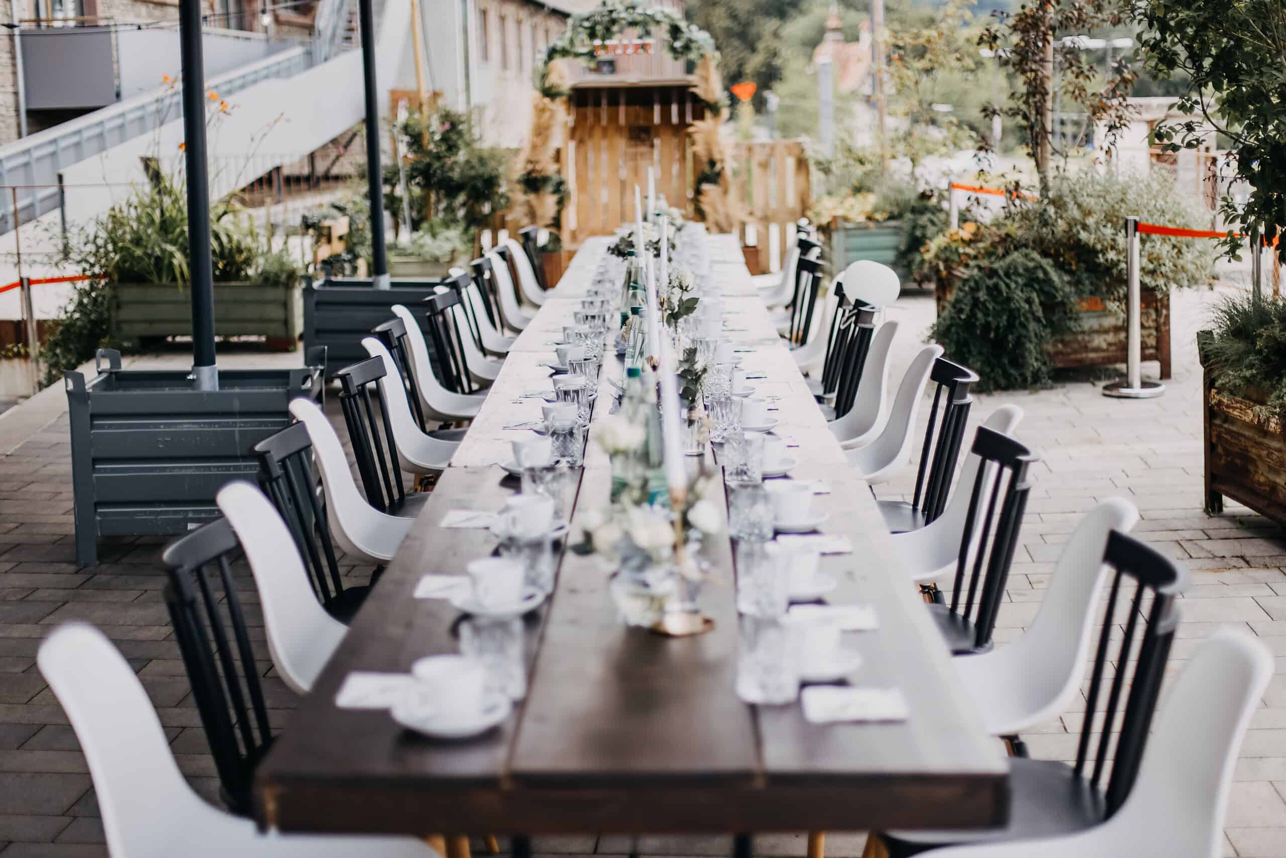 Hochzeit-Catering in Würzburg mit langer Hochzeittafel im Außenbereich auf einer Terrasse des Maschinenhaus Bürgerbräu