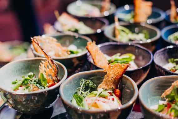 Von Markus Grein Catering angerichtete Bowls mit buntem Salat und knusprigen Brotchips beim Messe-Catering Frankfurt.