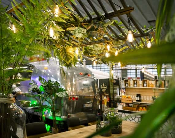 Messestand von Markus Grein mit vielen Pflanzen und Lampen und einem Airstream-Foodtruck in Frankfurt.