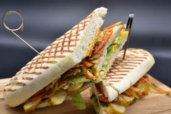 Gegrilltes Sandwich (Panini) mit Gemüse, serviert auf einem Holzbrett bei einem Event-Catering in Stuttgart.