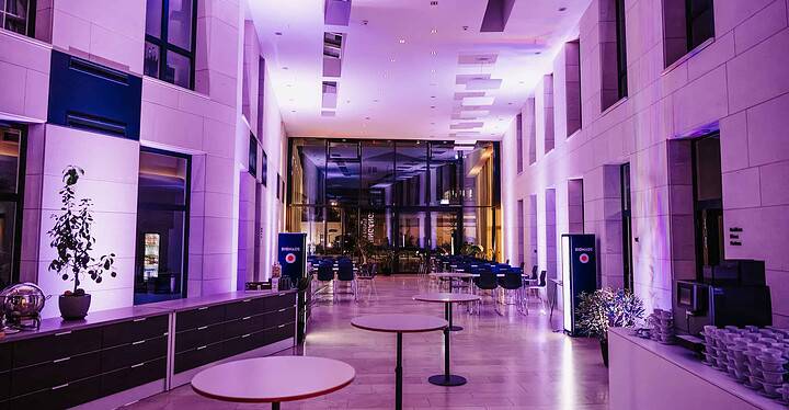Eingangsbereich der Würzburger Eventlocation Novum Conference & Events ist für ein Business-Event am Abend ausgeleuchtet.