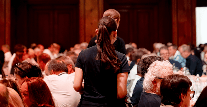 Servicemitarbeiterin navigiert durch voll besetzten Saal beim Gala-Dinner Franken Classics 2026