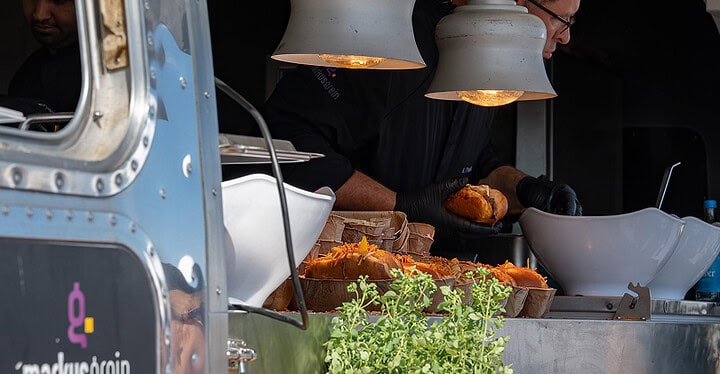 Koch bereitet im Airstream Foodtruck von Markus Grein Catering Streetfood zu