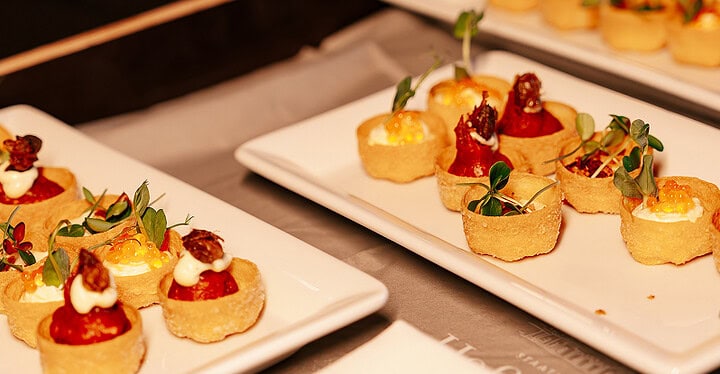 Fein angerichtete Canapés auf weißen Tellern als Häppchen zum Sektempfang einer Hochzeit