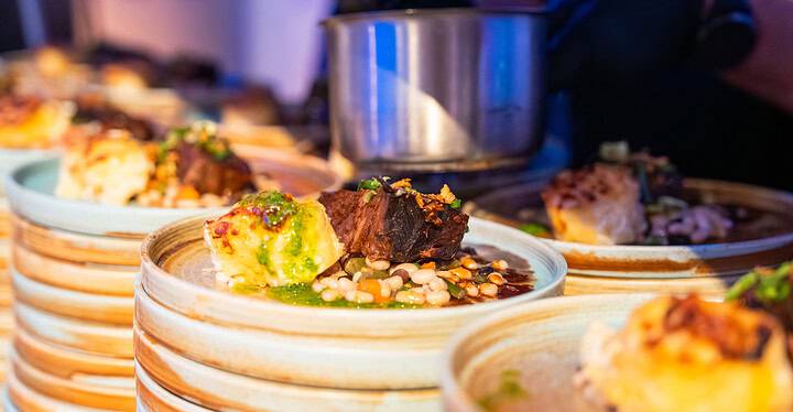 Im Rahmen eines Hochzeits-Caterings richtet ein Koch von Markus Grein Catering Hochzeitsessen mit Braten und Beilagen an.