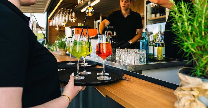 Servicepersonal serviert bunte Cocktails an der Bar während des Sektempfangs zur Hochzeit