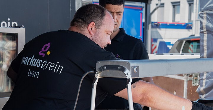 Mitarbeiter im Markus Grein Team Shirt bei der Zubereitung von Streetfood
