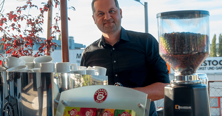 Barista bereitet beim Messe-Catering frischen Kaffee an einem Stand im Freien zu.