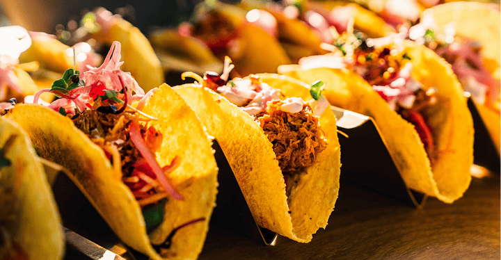 Bunt gefüllte Tacos aufgereiht auf dem Buffet beim Messe-Catering.