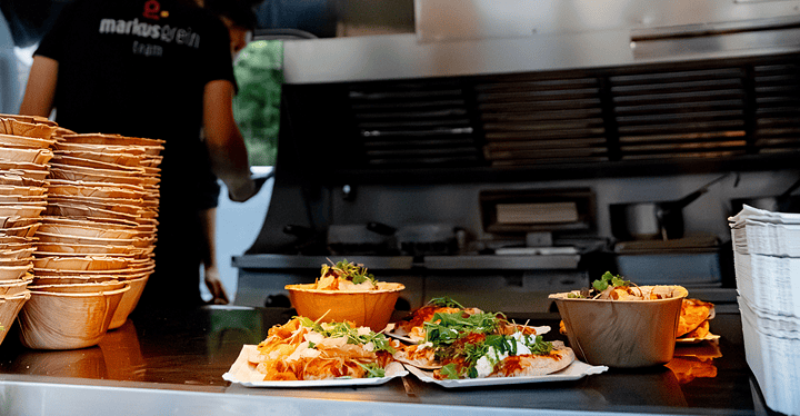 Fertig angerichtete Speiseschalen stehen bereit auf dem Tresen des Foodtrucks bei einem Messe-Catering.