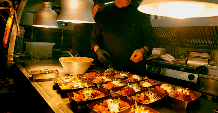 Markus Grein bereitet für ein Messe-Catering Speisen in Schälchen vor.