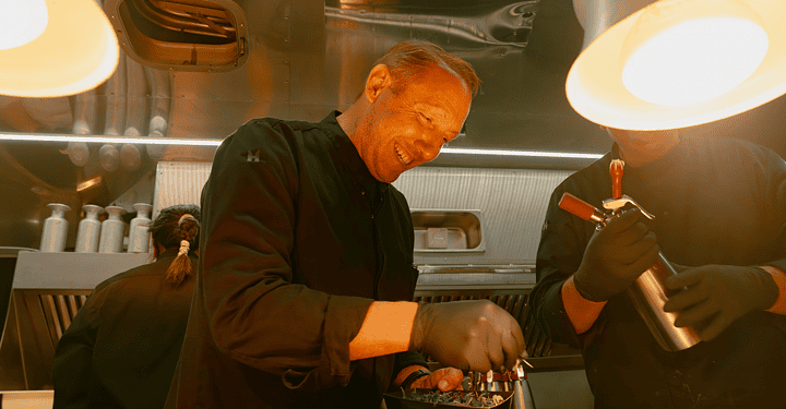 Beim Catering auf einer Messe bereitet Markus Grein essen in einem Foodtruck zu.