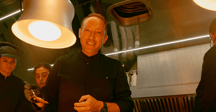 Markus Grein steht in einem Foodtruck auf einer Messe und lächelt freundlich in die Kamera.