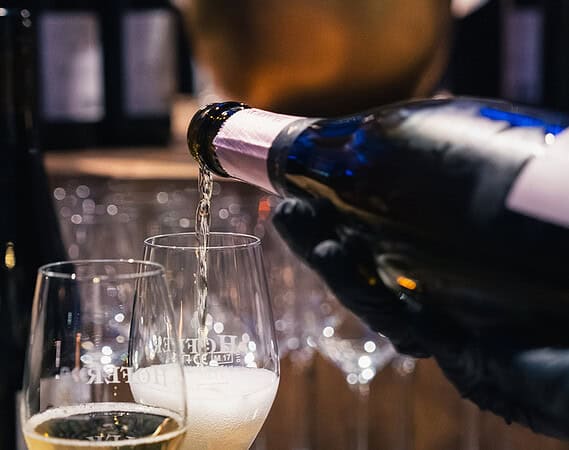 Sekt wird in Gläser gegossen als stilvoller Ausklang der Messe-Standparty.