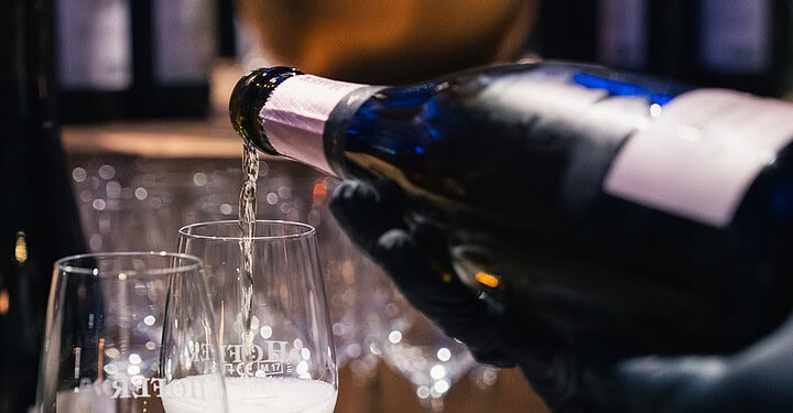 Sekt wird in Gläser gegossen als stilvoller Ausklang der Messe-Standparty.