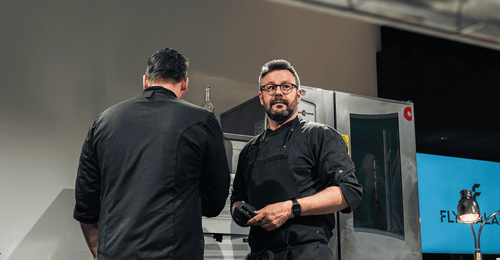 Zwei Köche stehen im Gespräch vor einem Kombidämpfer in der Foodtruck-Küche.