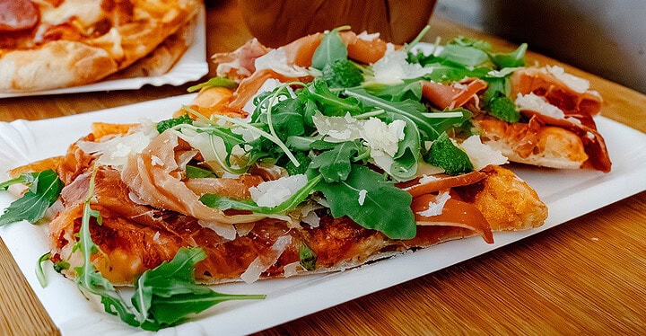 Pizza mit Parmaschinken und Rucola beim Pizza Catering für eine Hochzeit