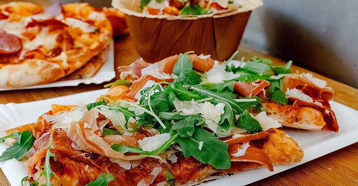 Buffet mit Pizza und Antipasti aus Rucola und Parmaschinken beim Foodtruck Catering
