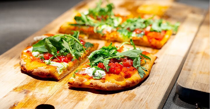 Pizza auf Pizzaschaufel aus Holz beim Event-Catering von Markus Grein beim DJ-Open-Air in Würzburg von vamos. und Aperol.