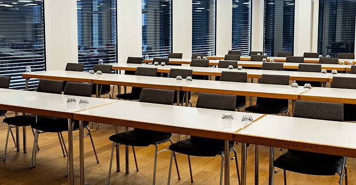 Konferenzsaal der Eventlocation Novum in Würzburg mit vielen Stühlen und Tischen in parlamentarischer Bestuhlung.