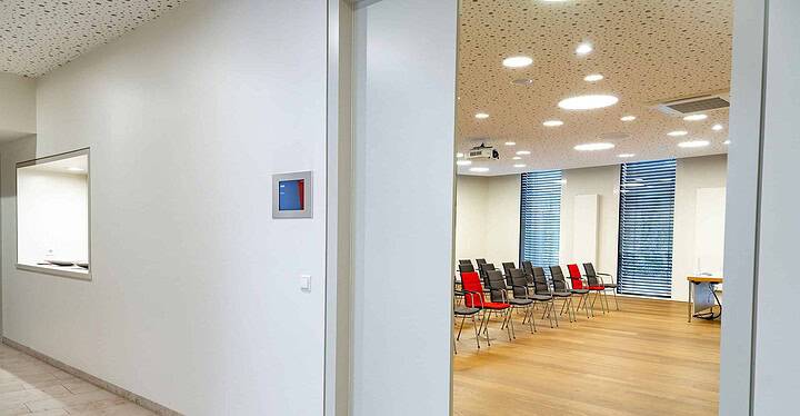 Blick vom Gang in einen bestuhlten Tagungsraum der modernen Würzburger Tagungslocation Novum Conference & Events.