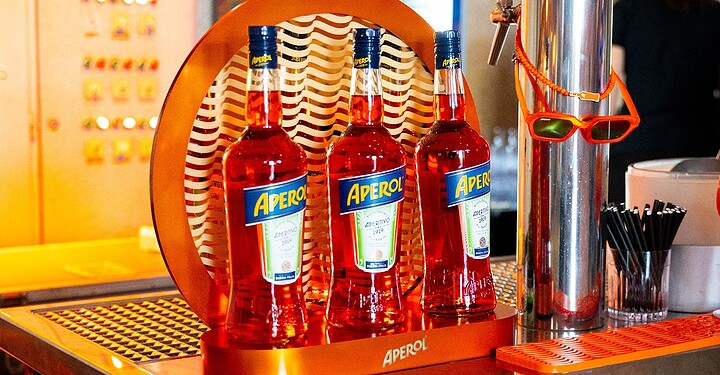 Drei Flaschen Aperol stehen auf der Bar der Würzburger Eventlocation Maschinenhaus beim Event vamos. x Aperol.