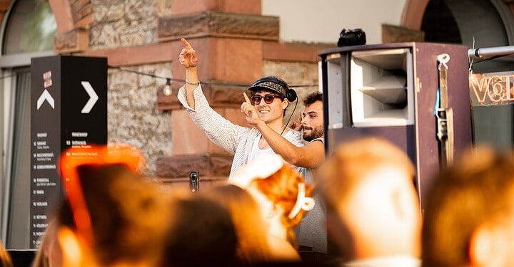 Tanzende DJs beim Event von vamos. und Aperol auf der Terrasse der Würzburger Eventlocation Maschinenhaus.